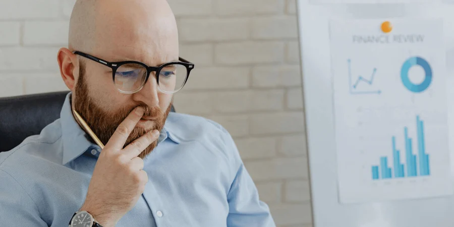 Man thinking in front of graphs